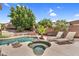 An inviting backyard pool and spa with lounge chairs, lush trees, and a beautiful brick accent wall at 6352 W Hackamore Dr, Phoenix, AZ 85083