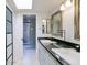 Bathroom featuring double sinks with black countertops, modern fixtures, and a bright skylight at 6611 N 79Th Pl, Scottsdale, AZ 85250