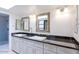 Bathroom featuring a double vanity with updated lighting, fixtures, mirrors, and a glass enclosed shower at 6611 N 79Th Pl, Scottsdale, AZ 85250
