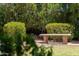 Relaxing backyard featuring a stone bench surrounded by manicured greenery and mature trees at 6717 E Aire Libre Ln, Scottsdale, AZ 85254