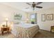 Relaxing bedroom with a floral-patterned comforter, soft lighting, and a view of the peaceful neighborhood at 6717 E Aire Libre Ln, Scottsdale, AZ 85254