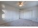 This carpeted bedroom has a ceiling fan and a closet with sliding doors for storage at 7035 N 11Th Pl, Phoenix, AZ 85020