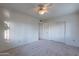 This carpeted bedroom has a ceiling fan and a closet with sliding doors for storage at 7035 N 11Th Pl, Phoenix, AZ 85020