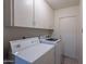 Bright laundry room features a white washer and dryer plus ample overhead storage at 7035 N 11Th Pl, Phoenix, AZ 85020