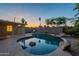 Enjoy a backyard pool with rock features, complemented by lush landscaping and a serene sunset at 7035 N 11Th Pl, Phoenix, AZ 85020