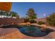 Backyard swimming pool is surrounded by decorative rockwork, mature trees and a privacy fence at 7035 N 11Th Pl, Phoenix, AZ 85020