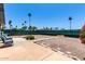 Large backyard with a patio, gravel landscaping, palm trees, and a private green fence at 7343 E Juanita Ave, Mesa, AZ 85209
