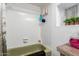 Bathroom boasts a combined shower and tub area with wall-mounted toiletries and a small garden view window at 7343 E Juanita Ave, Mesa, AZ 85209