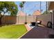 A cozy backyard featuring artificial turf, a brick patio, an outdoor furniture set, and string lights at 7716 S Rita Ln, Tempe, AZ 85284