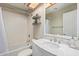 Bright bathroom featuring a shower-tub combination, white tile, and a marble vanity at 7716 S Rita Ln, Tempe, AZ 85284