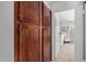 Large, stained-wood closet doors leading to a carpeted bedroom with natural light and cozy furnishings at 7716 S Rita Ln, Tempe, AZ 85284