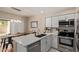 Modern kitchen boasts stainless steel appliances, white cabinets, and access to the backyard at 7716 S Rita Ln, Tempe, AZ 85284