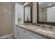 Bathroom featuring double sinks, granite countertop, decorative cabinets, and a glass-enclosed shower at 8343 E Quarterhorse Trl, Scottsdale, AZ 85258