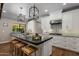 Bright kitchen with black island, pendant lighting, white cabinetry, and stainless steel appliances at 8343 E Quarterhorse Trl, Scottsdale, AZ 85258