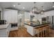 Bright kitchen with large island, white cabinetry, pendant lighting and stainless steel appliances at 8343 E Quarterhorse Trl, Scottsdale, AZ 85258
