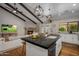 Bright open floor plan kitchen with island, white cabinetry, fireplace and modern lighting at 8343 E Quarterhorse Trl, Scottsdale, AZ 85258