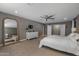 Neutral toned main bedroom with fan, accent mirror, and dresser at 8343 E Quarterhorse Trl, Scottsdale, AZ 85258