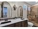 Detailed bathroom featuring decorative mirrors, sconces, and a tile shower stall at 10310 N 135Th Way, Scottsdale, AZ 85259