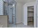 A modern bathroom boasts a glass shower with gray stone details and an open walk-in closet at 10310 N 135Th Way, Scottsdale, AZ 85259