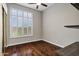 A well-lit bedroom with hardwood floors and a window with shuttered blinds at 10310 N 135Th Way, Scottsdale, AZ 85259