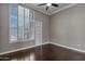 Bright bedroom features a ceiling fan, large window, and gleaming hardwood floors at 10310 N 135Th Way, Scottsdale, AZ 85259