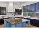 Modern kitchen featuring a large island, dark cabinets, and stylish light fixtures at 10310 N 135Th Way, Scottsdale, AZ 85259