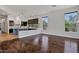 Open-concept living space connecting seamlessly to kitchen area with wood floors and natural light at 10310 N 135Th Way, Scottsdale, AZ 85259