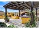 Inviting outdoor kitchen featuring a pergola, custom tile work, a built-in grill, and a cozy fireplace at 10310 N 135Th Way, Scottsdale, AZ 85259