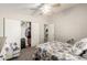 Neutral bedroom with floral bedding, ceiling fan, and closet space at 10618 W Prairie Ln, Casa Grande, AZ 85193