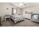 Neutral bedroom with floral bedding, ceiling fan, and white dresser at 10618 W Prairie Ln, Casa Grande, AZ 85193