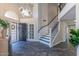 Grand foyer with soaring ceilings, iron staircase, wood-look floors, and decorative chandelier at 12042 S 44Th St, Phoenix, AZ 85044