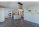 Bright kitchen with modern lighting, stainless steel appliances, and bar top looking into the living room at 12042 S 44Th St, Phoenix, AZ 85044