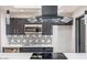 Modern kitchen featuring dark cabinets, stainless steel appliances, stylish backsplash, and sleek countertops at 12431 N 30Th Ave, Phoenix, AZ 85029