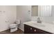 Bathroom featuring a modern toilet, mirror, sink, towel rack and dark wood cabinetry at 1255 S Rialto -- # 115, Mesa, AZ 85209