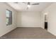 Bright bedroom with a ceiling fan, a window letting in natural light, and an ensuite bathroom at 1255 S Rialto -- # 115, Mesa, AZ 85209
