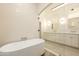 Bathroom featuring a soaking tub, glass shower, dual sinks, and white cabinets at 12776 N 78Th St, Scottsdale, AZ 85260