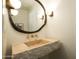 Stylish bathroom featuring a stone sink, unique fixtures and a decorative mirror at 12776 N 78Th St, Scottsdale, AZ 85260