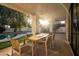 Outdoor covered patio features a dining table, overlooking a pool and putting green at 12776 N 78Th St, Scottsdale, AZ 85260