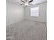 Well-lit bedroom with neutral carpet, ceiling fan, and a window for natural light at 1332 E Charleston Ave, Phoenix, AZ 85022