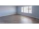 Bedroom with modern vinyl floors, neutral walls, large window with blinds, and ample natural light at 1402 E Guadalupe Rd # 207, Tempe, AZ 85283