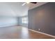 The bedroom boasts a ceiling fan, a large window with blinds, and stylish two-tone walls at 1402 E Guadalupe Rd # 207, Tempe, AZ 85283