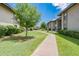 Well-maintained courtyard with lush landscaping, walking path, and mature trees at 1402 E Guadalupe Rd # 207, Tempe, AZ 85283
