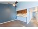 Well lit room with ceiling fan looking into the kitchen pass through at 1402 E Guadalupe Rd # 207, Tempe, AZ 85283