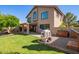 Backyard features lawn, lake view, covered patio, and a playhouse at 1575 S Pennington Dr, Chandler, AZ 85286