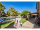 Backyard with lake view, lush landscaping, playhouse, and covered patio at 1575 S Pennington Dr, Chandler, AZ 85286