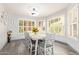 Bright dining room with ample natural light, white table and chairs, and wood-look floors at 1575 S Pennington Dr, Chandler, AZ 85286