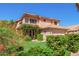 Charming two-story home with a terra cotta roof, flowering bushes, and manicured lawn at 1575 S Pennington Dr, Chandler, AZ 85286