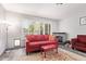 Bright living room featuring a cozy red sofa, shutters, and decorative fireplace at 1575 S Pennington Dr, Chandler, AZ 85286