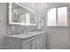 Bathroom featuring double sinks, a large mirror, decorative backsplash, and a window for natural light at 1613 W Flower N Cir, Phoenix, AZ 85015