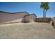 The backyard features a minimalist design with gravel, a fence, and a lone palm tree at 17232 N 29Th Ave, Phoenix, AZ 85053